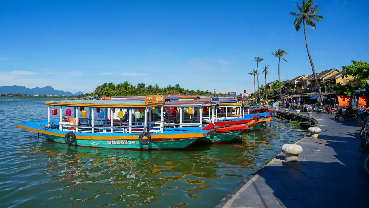 Colorful wooden boats moored along the Thu Bon river in Hoi An Ancient Town.